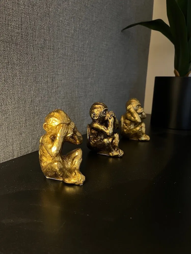 Three wise monkeys statues in gold
