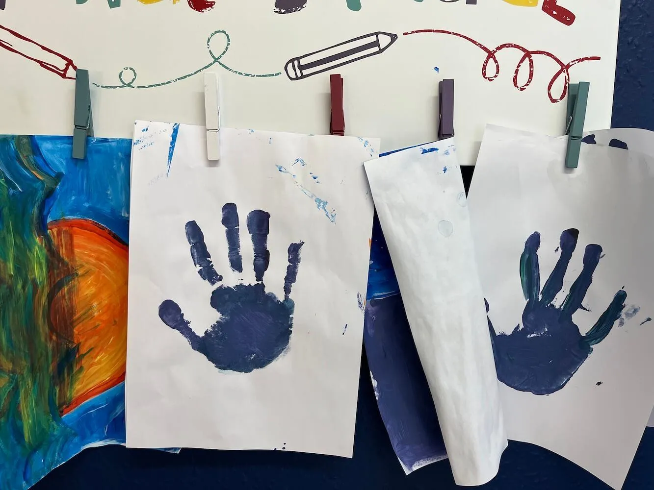 Photograph of children's artwork and painted hand prints