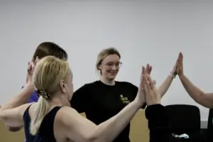 Outside in project - services users and trainers joining hands in a circle