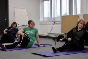 Outside in project service users performing stretches on yoga mats