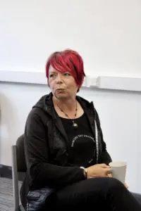Service user of the outside in project sitting with a cup of coffee