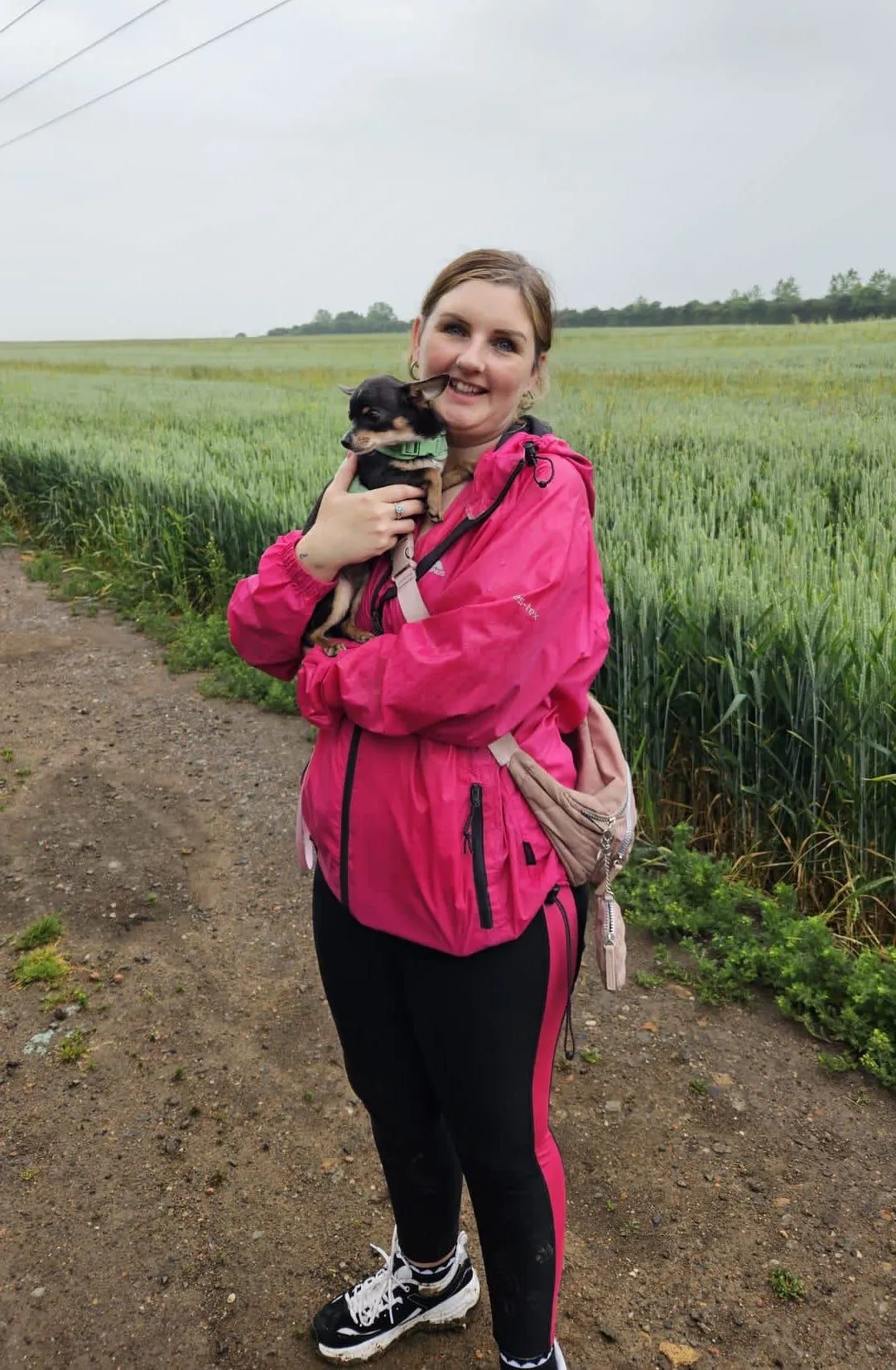 Nikki Paterson holding her dog while walking through a field